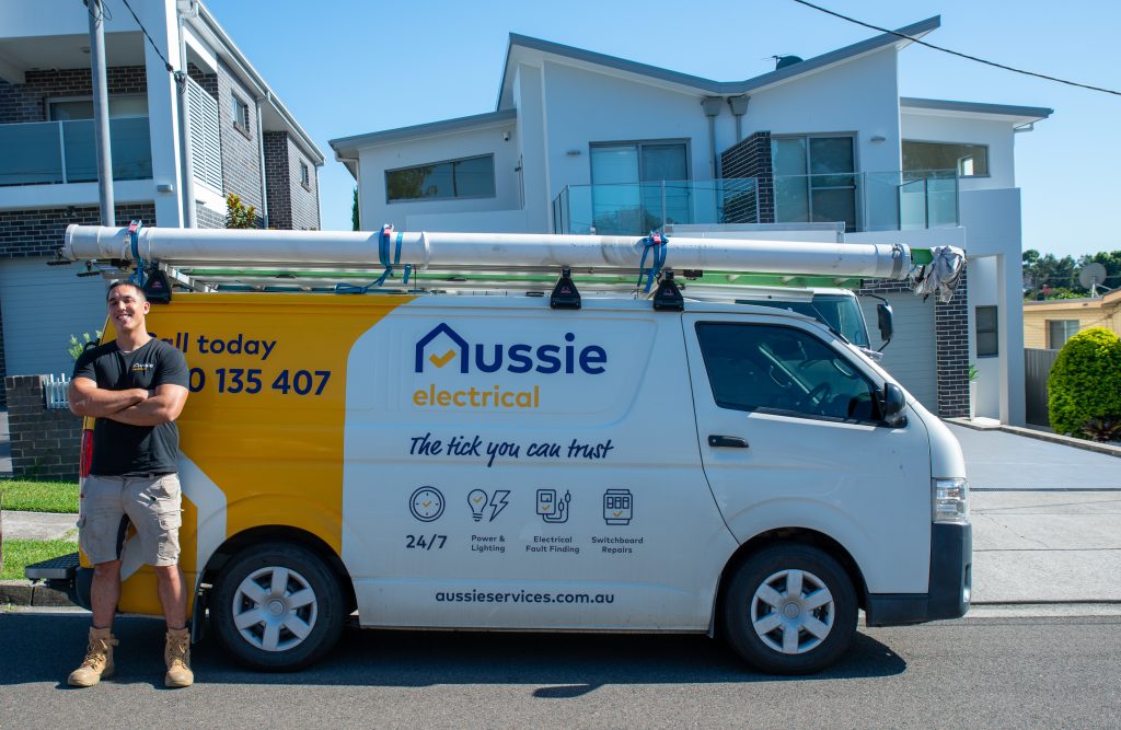 The electrician in-front of their Aussie Electrical and Plumbing company van.