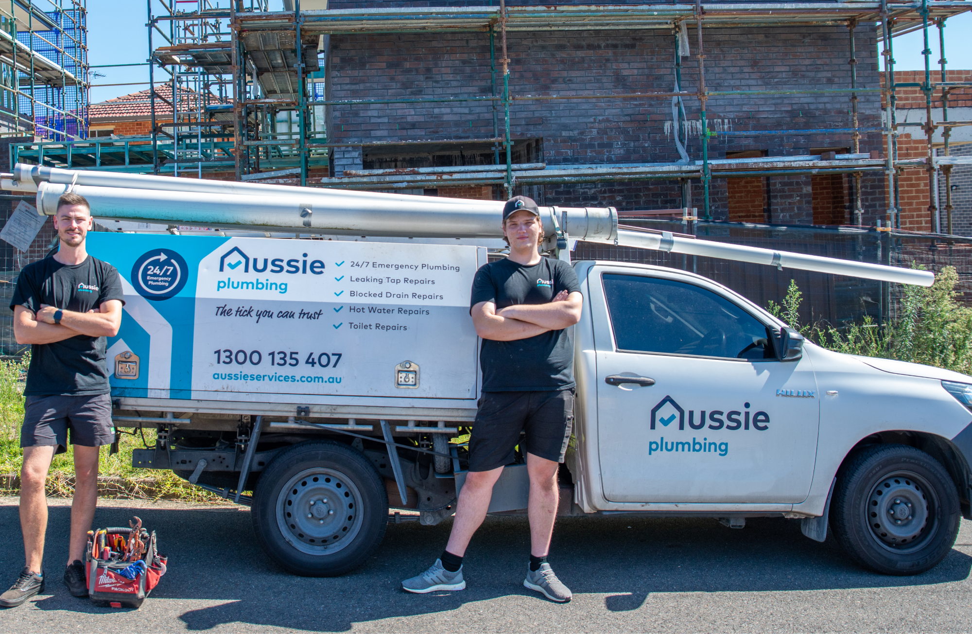 A plumber in-front if their Aussie Electrical and plumbing company van.